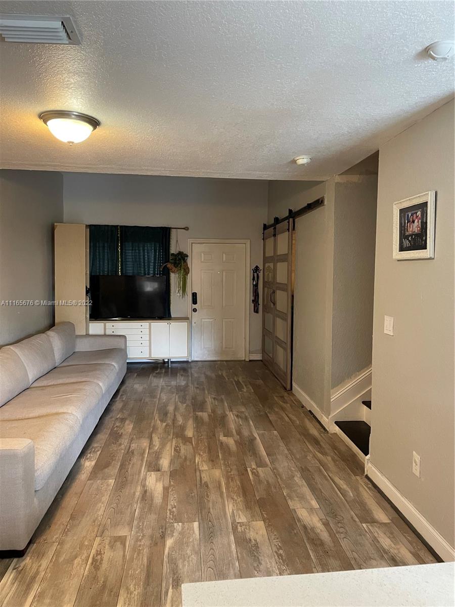 22025 Southwest 88th Path Cutler Bay, FL 33190 - Photo 11 of 34 a living room with a couch and a flat screen tv