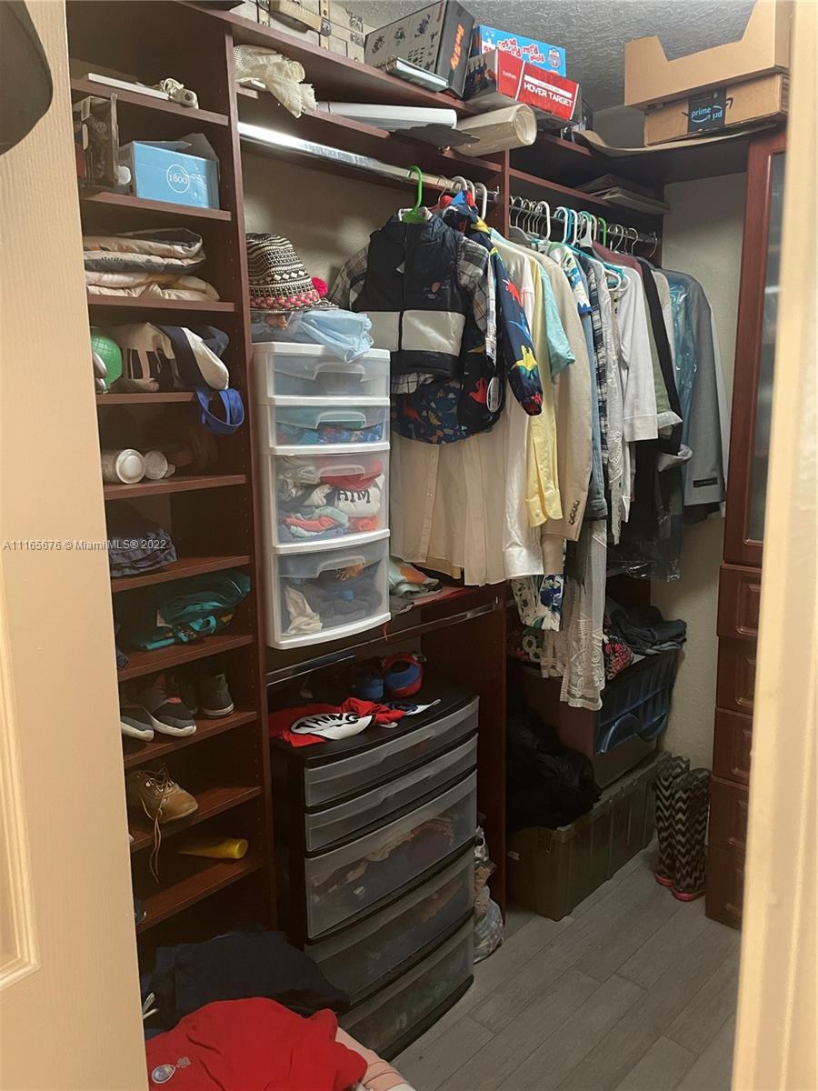 22025 Southwest 88th Path Cutler Bay, FL 33190 - Photo 20 of 34 a view of walk in closet with clothes and shoes