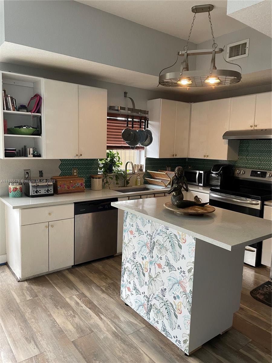 22025 Southwest 88th Path Cutler Bay, FL 33190 - Photo 2 of 34 a kitchen with stainless steel appliances granite countertop a sink a stove and a wooden floors