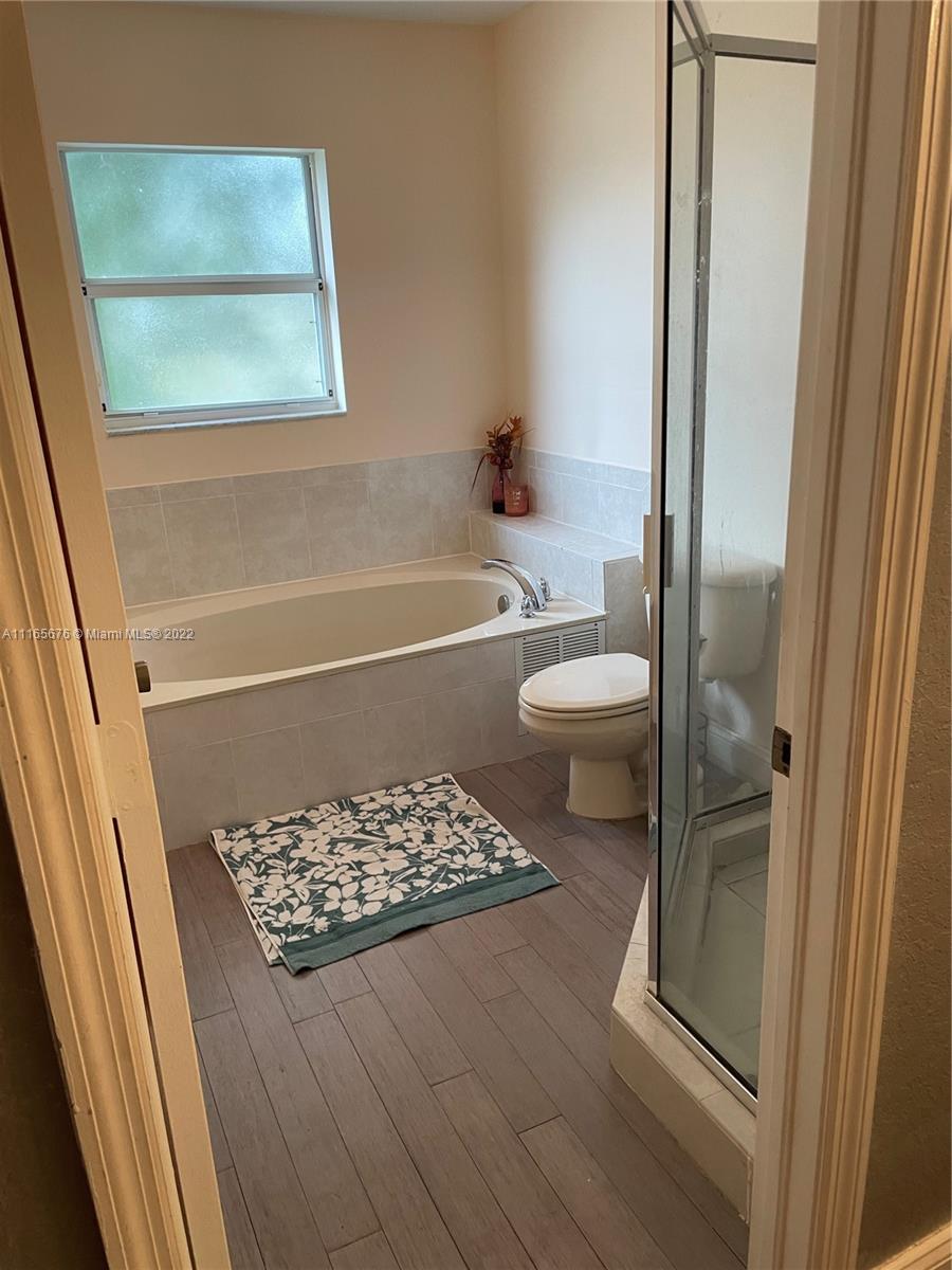 22025 Southwest 88th Path Cutler Bay, FL 33190 - Photo 22 of 34 a bathroom with a tub and a toilet