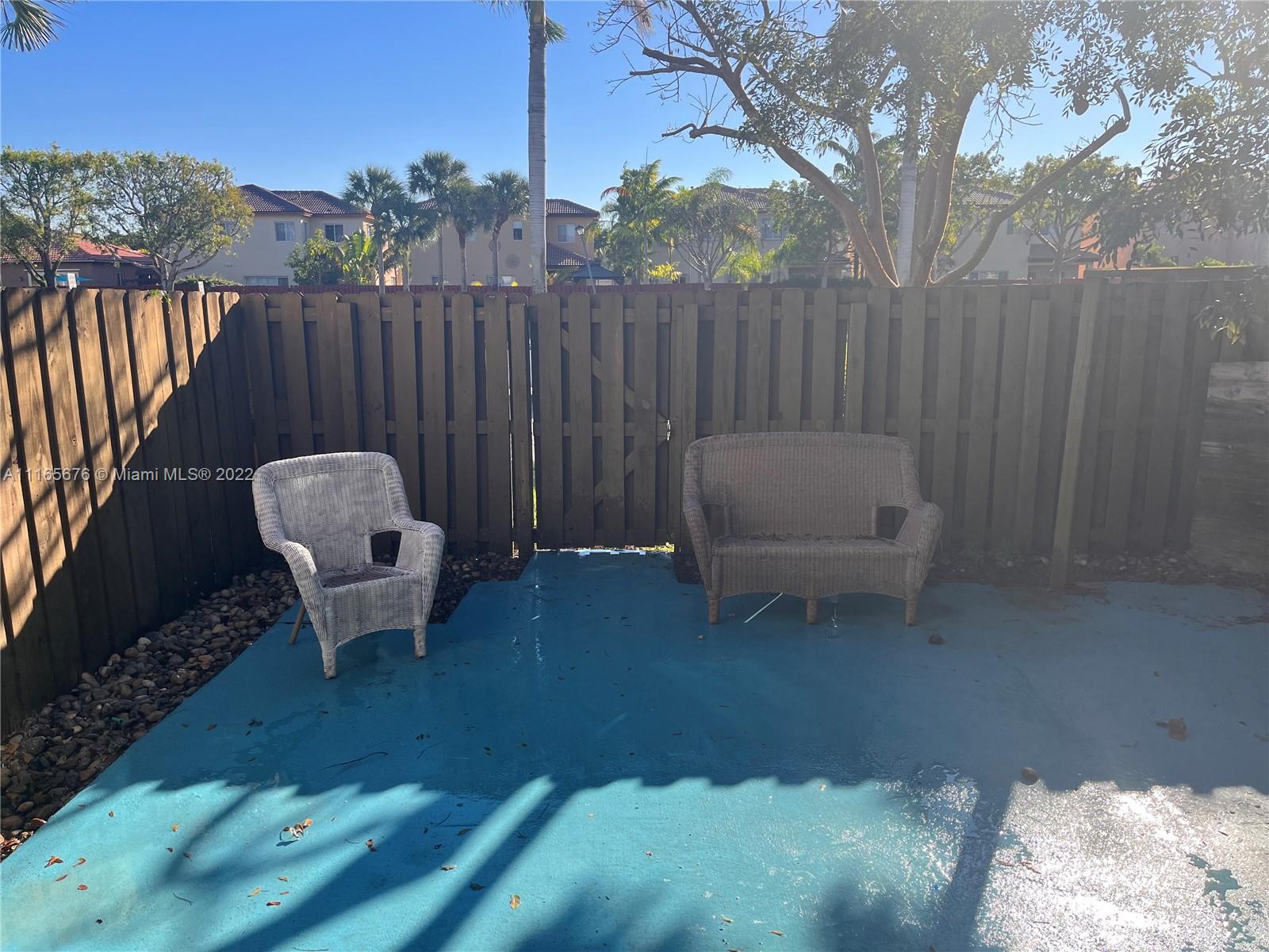 22025 Southwest 88th Path Cutler Bay, FL 33190 - Photo 28 of 34 a backyard of a house with table and chairs
