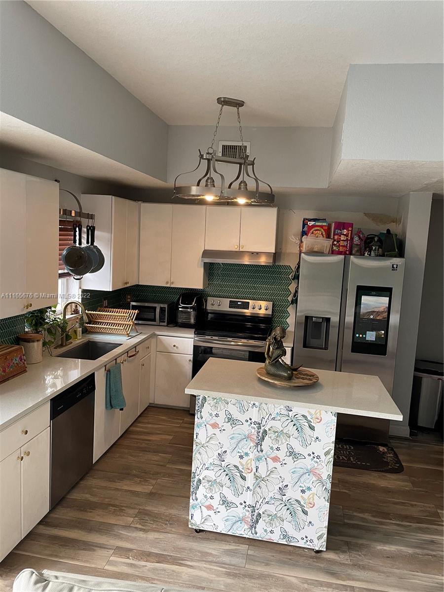 22025 Southwest 88th Path Cutler Bay, FL 33190 - Photo 3 of 34 a kitchen with stove top oven a sink and dishwasher