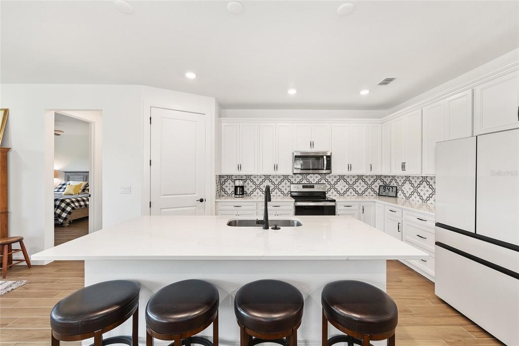 8989 Southwest 57th Pl Road Ocala, FL 34481 - Photo 12 of 47 a kitchen with a dining table chairs sink and stove
