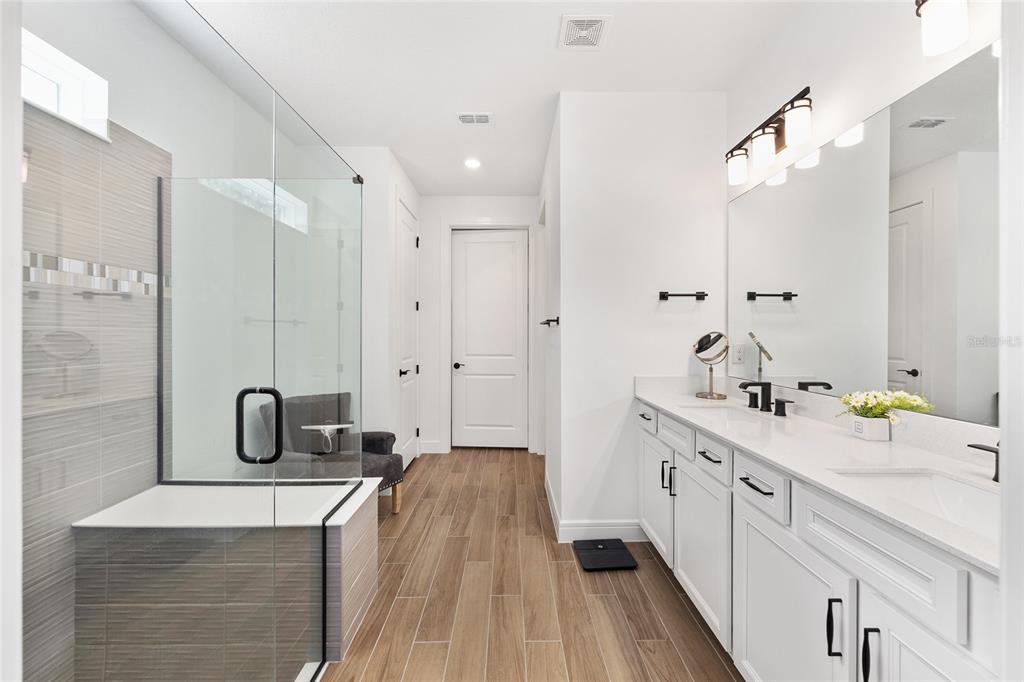 8989 Southwest 57th Pl Road Ocala, FL 34481 - Photo 25 of 47 a bathroom with a double vanity sink double mirror and bathtub