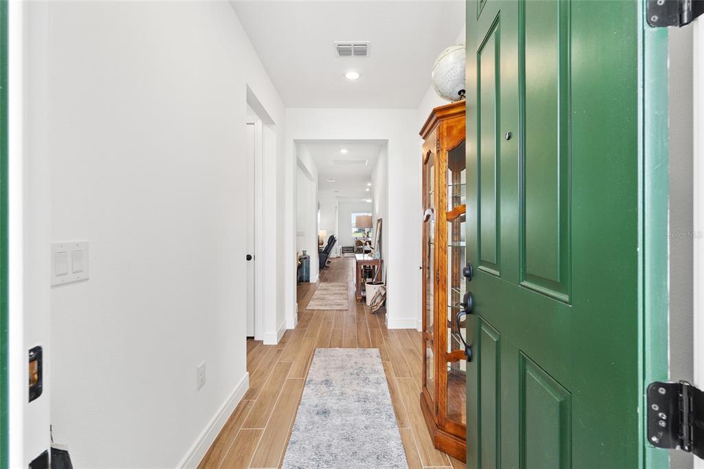 8989 Southwest 57th Pl Road Ocala, FL 34481 - Photo 4 of 47 a hallway with cabinets and wooden floor