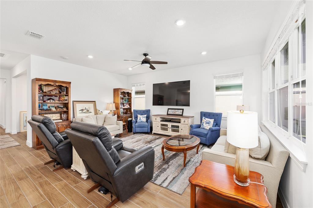 8989 Southwest 57th Pl Road Ocala, FL 34481 - Photo 8 of 47 a living room with furniture a flat screen tv and kitchen view