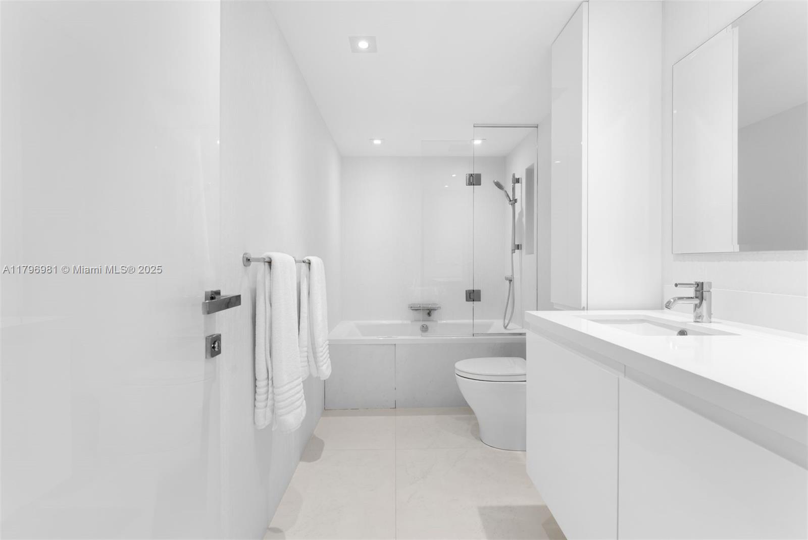 9801 Collins Avenue, Unit 17P Bal Harbour, FL 33154 - Photo 15 of 31 a bathroom with a toilet a sink a mirror a bathtub and shower