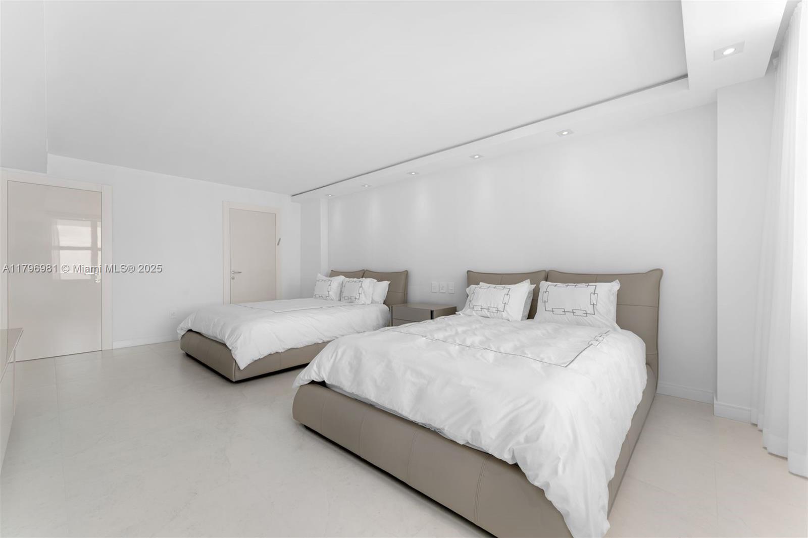 9801 Collins Avenue, Unit 17P Bal Harbour, FL 33154 - Photo 19 of 31 a bedroom with two beds and lamp