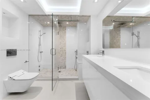 a bathroom with a double vanity sink toilet and shower