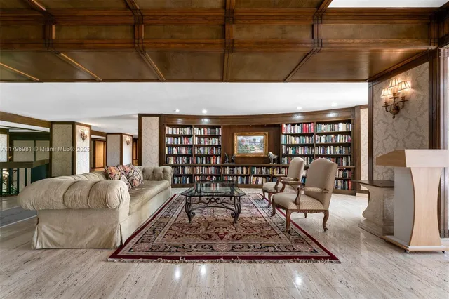 a living room with furniture a rug and a book shelf