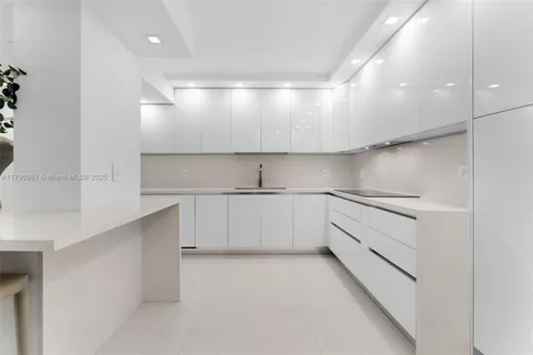 a kitchen with white cabinets and white stainless steel appliances