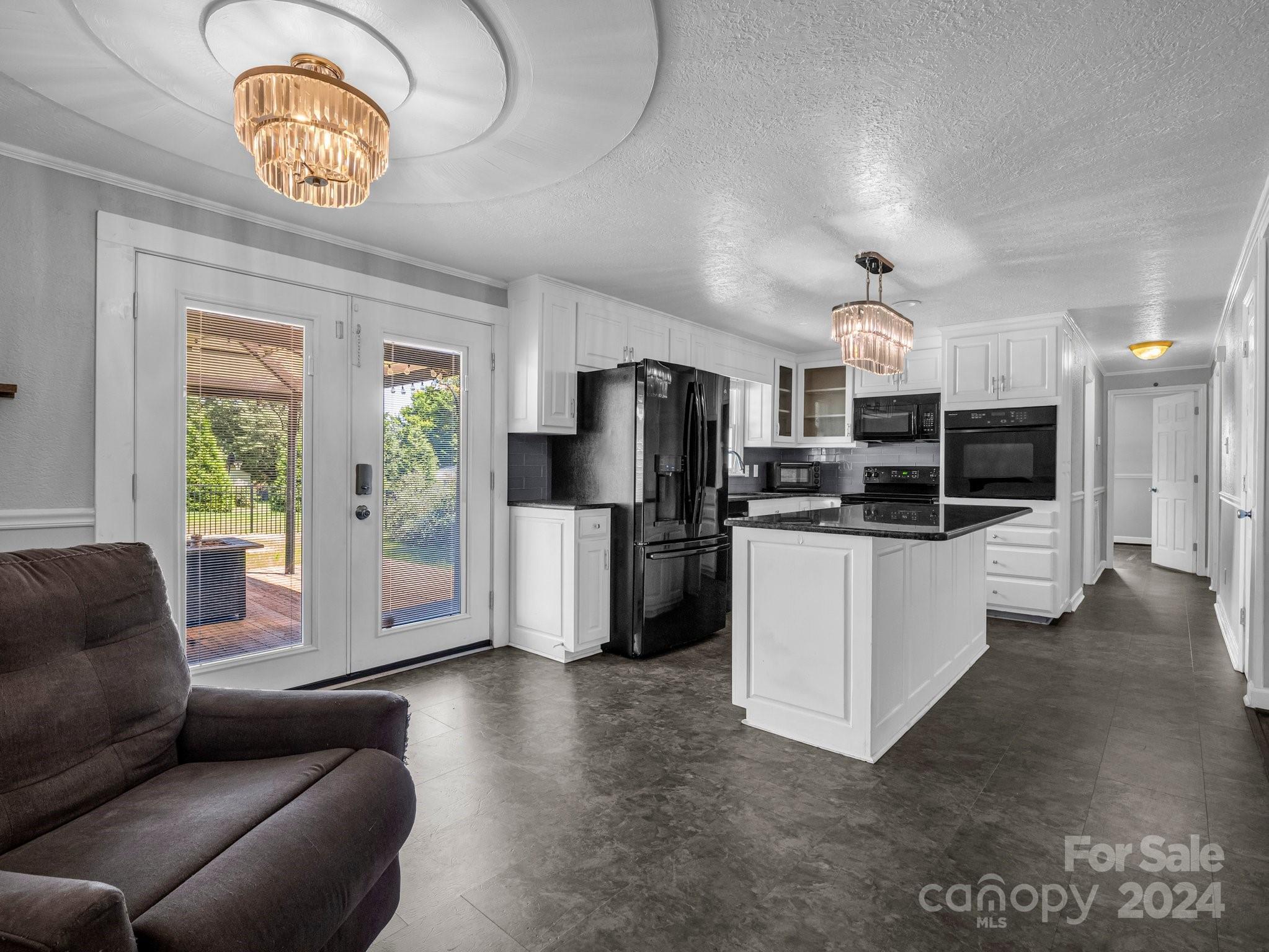3401 Spencer Road Conover, NC 28613 - Photo 6 of 34 a kitchen with stainless steel appliances granite countertop a refrigerator a stove a microwave oven a sink with island and chairs