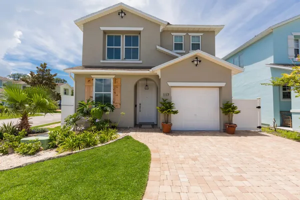 a front view of a house with a yard and potted plants