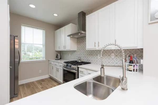 a kitchen with stainless steel appliances granite countertop a sink stove and cabinets