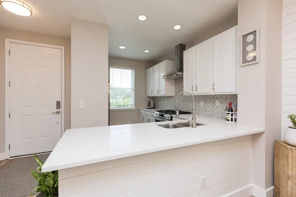 a kitchen with kitchen island a sink a stove a center island and cabinets