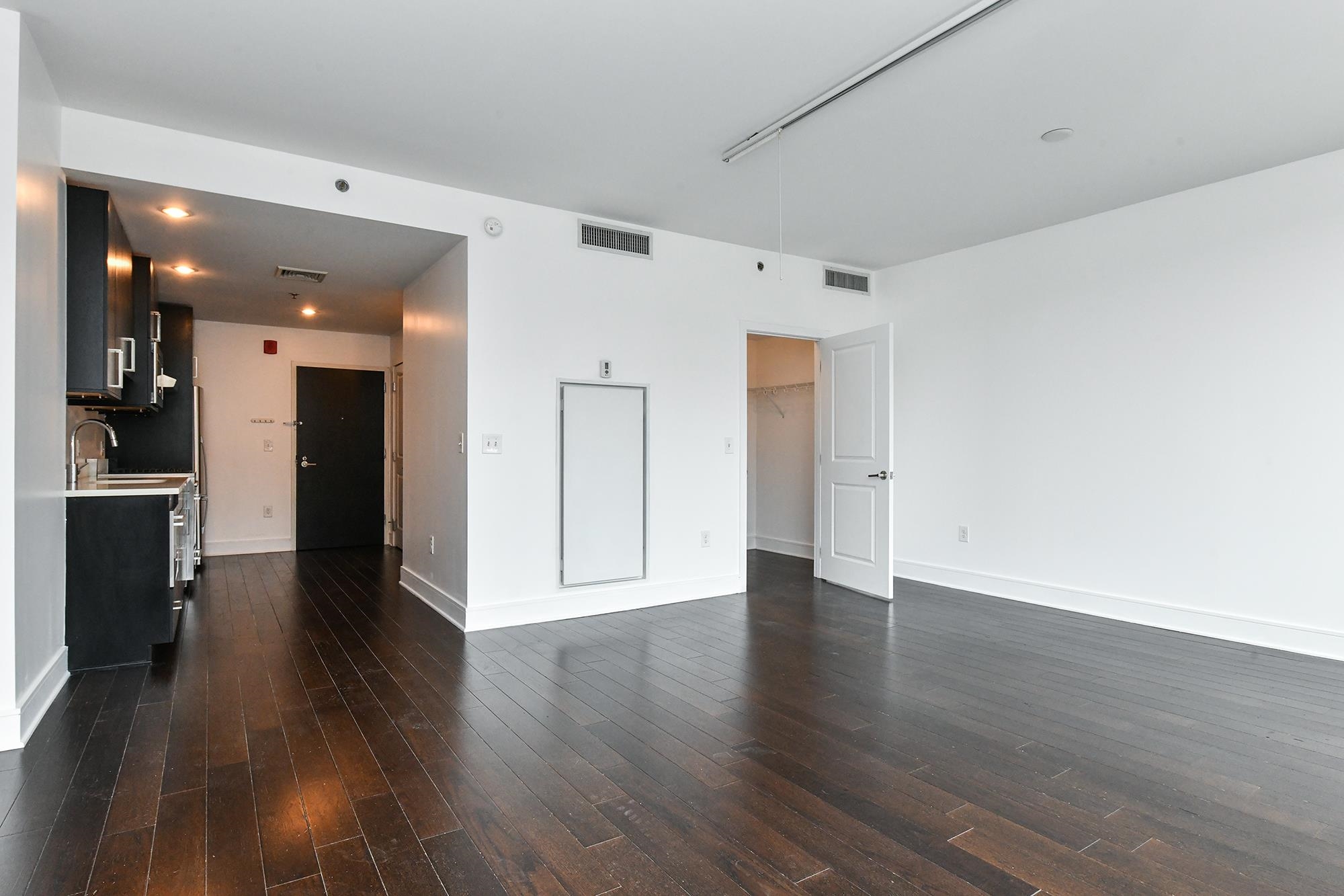 1100 Maxwell Lane, Unit 517 Hoboken, NJ 07030 - Photo 2 of 17 a view of a big room with wooden floor and windows