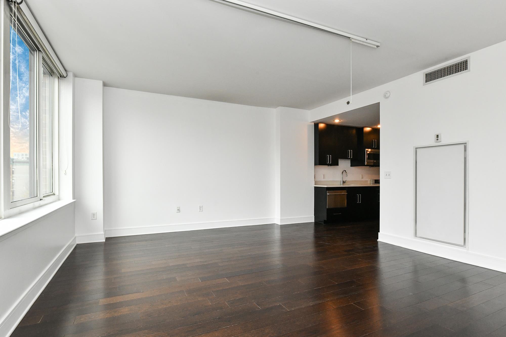 1100 Maxwell Lane, Unit 517 Hoboken, NJ 07030 - Photo 7 of 17 an empty room with wooden floor and windows