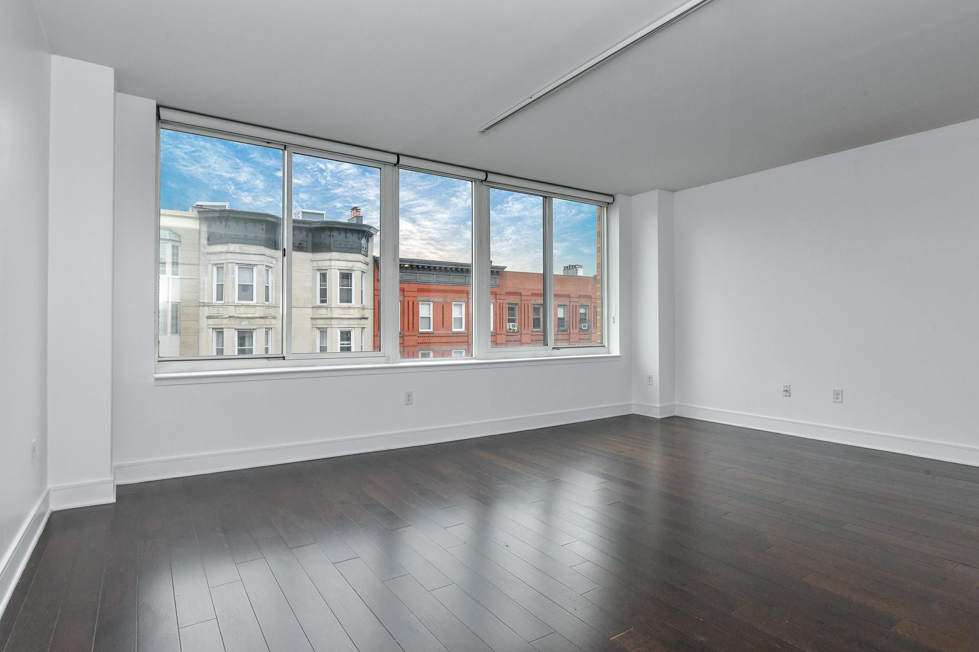 1100 Maxwell Lane, Unit 517 Hoboken, NJ 07030 - Photo 8 of 17 a view of an empty room with wooden floor and a window