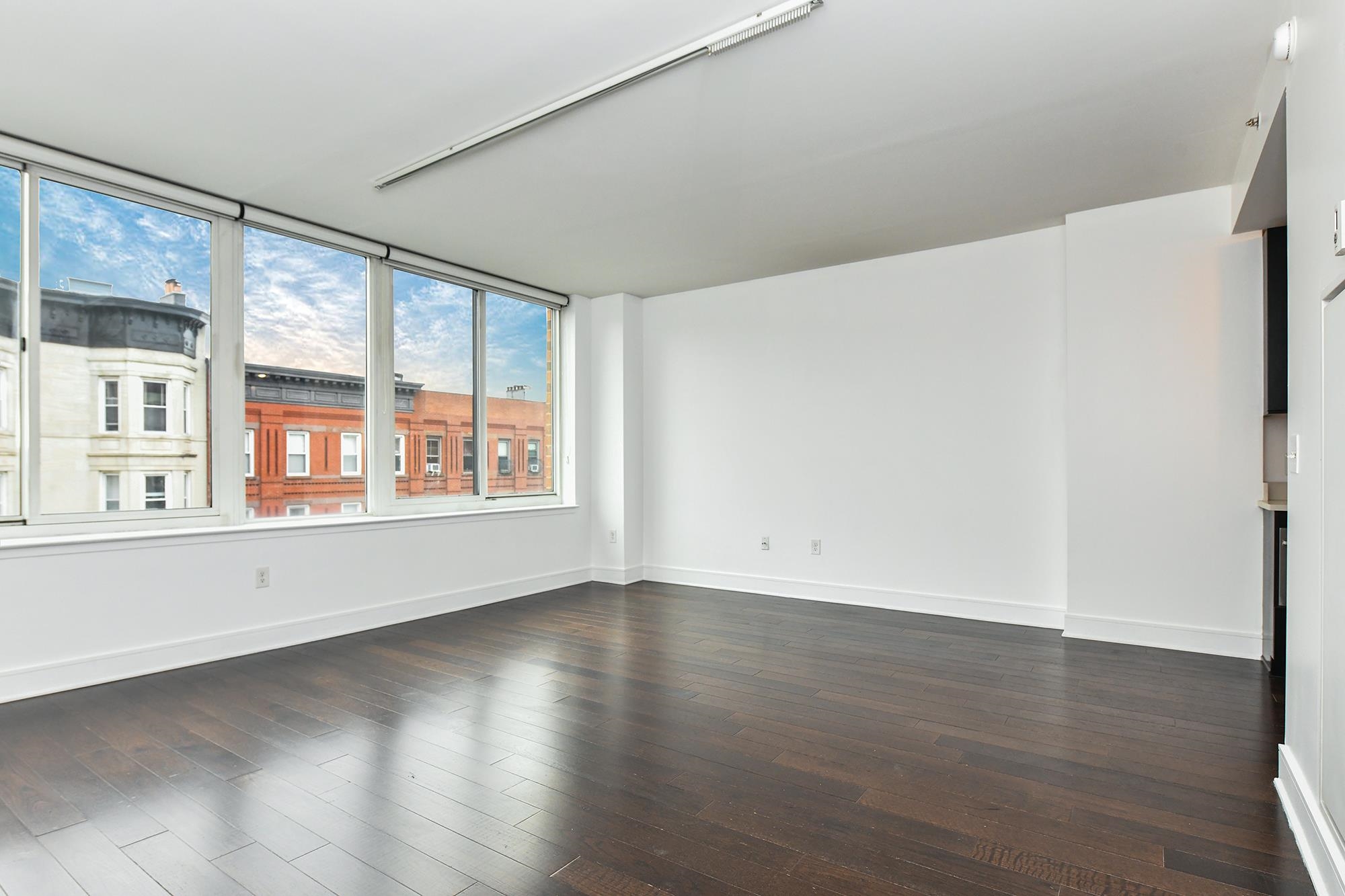 1100 Maxwell Lane, Unit 517 Hoboken, NJ 07030 - Photo 9 of 17 a view of an empty room with wooden floor and a window