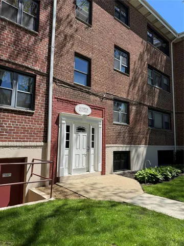 a front view of a house with a garden and yard