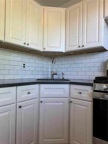 a kitchen with white cabinets and white appliances