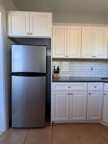 a kitchen with cabinets and a refrigerator