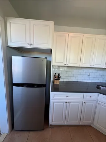 a kitchen with a sink a refrigerator and cabinets