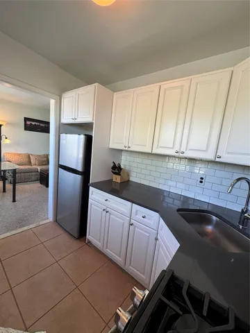 a kitchen with a sink a refrigerator and cabinets