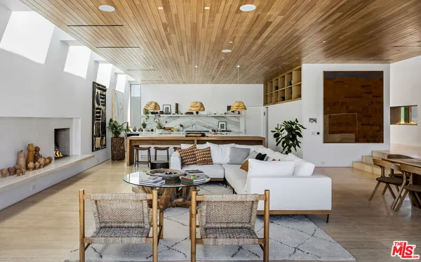 a living room with furniture a table and a large window