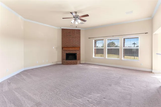 an empty room with chandelier fan and windows