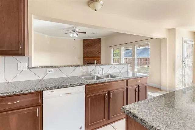 a kitchen with a sink granite counter tops and a wooden cabinets