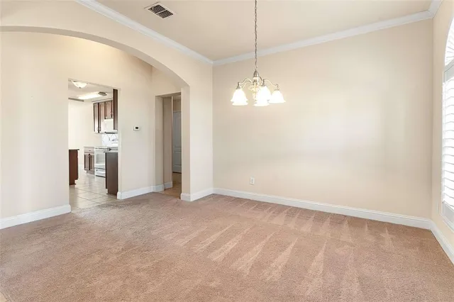an empty room with chandelier fan