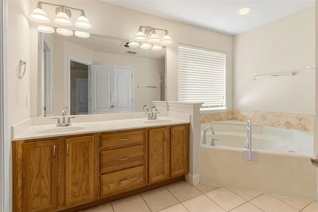 a bathroom with a tub sink and mirror