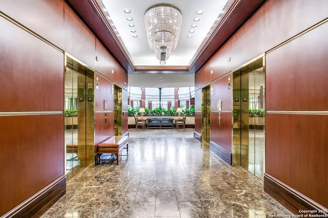 a view of a hallway with wooden floor and a potted plant