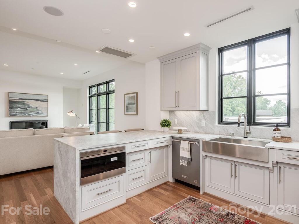 1333 Queens Road, Unit B4 Charlotte, NC 28207 - Photo 13 of 27 a kitchen that has a sink a stove and a table in it