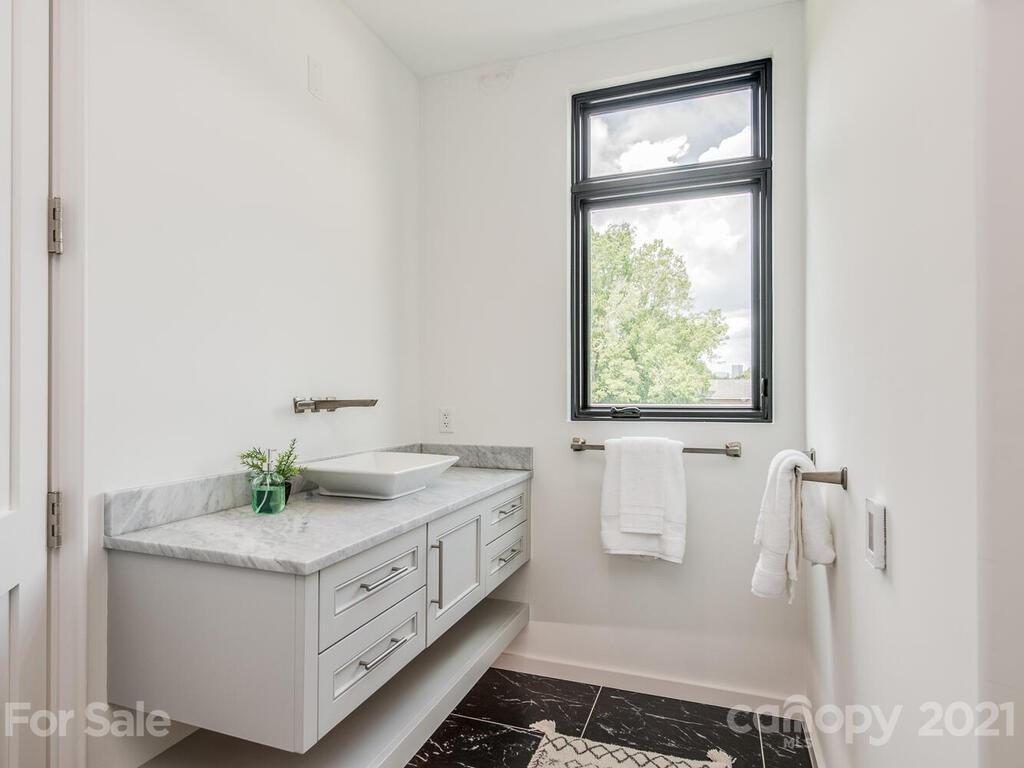 1333 Queens Road, Unit B4 Charlotte, NC 28207 - Photo 24 of 27 a bathroom with a double vanity sink a mirror and a bathtub