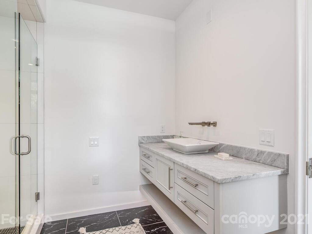1333 Queens Road, Unit B4 Charlotte, NC 28207 - Photo 25 of 27 a bathroom with a granite countertop sink and white cabinets