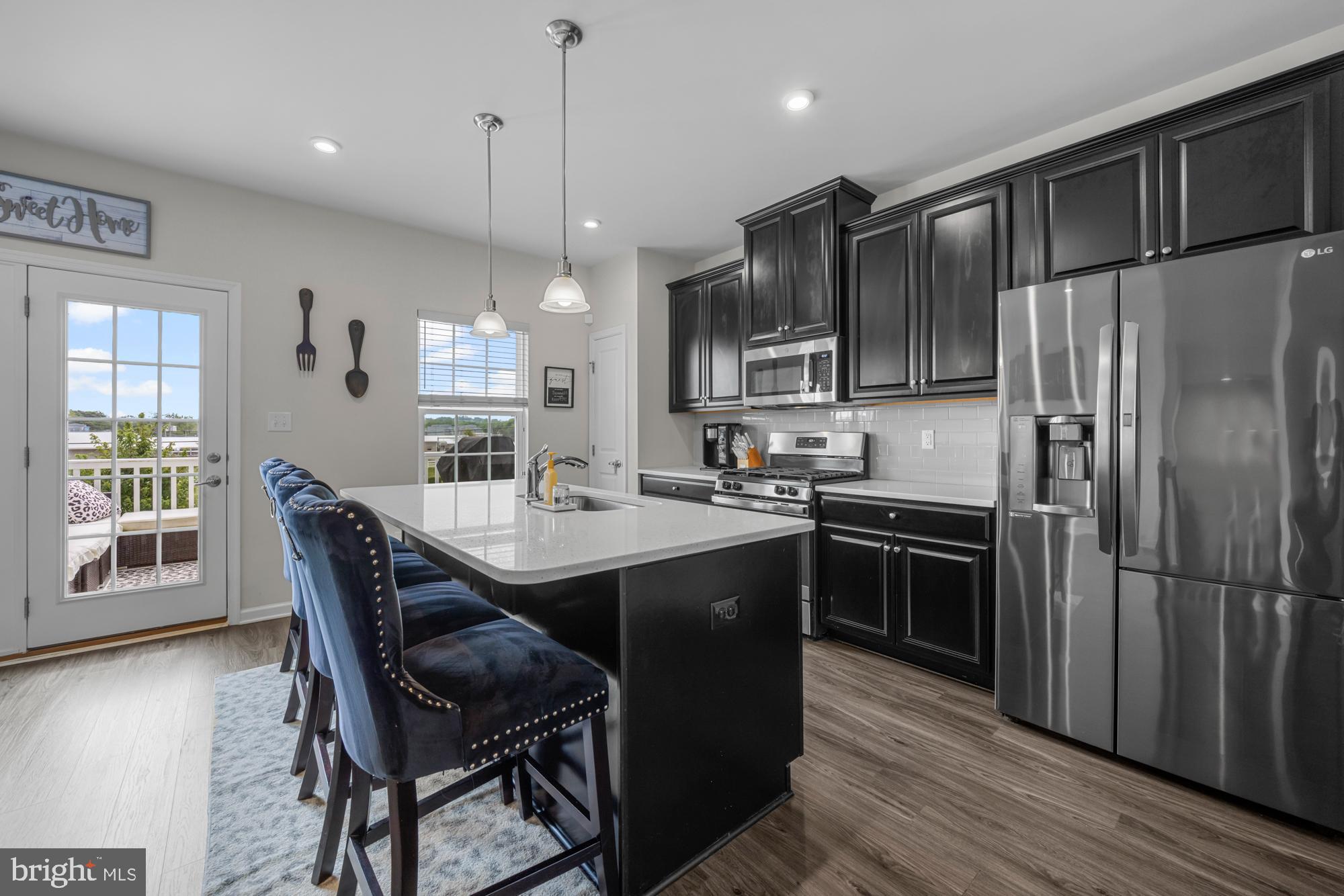 607 Sammy Street Swedesboro, NJ 08085 - Photo 12 of 37 a kitchen with kitchen island a wooden floor and stainless steel appliances