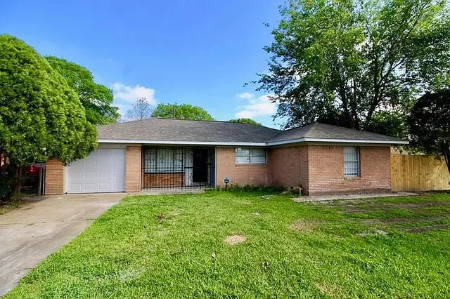 a front view of a house with yard and trees