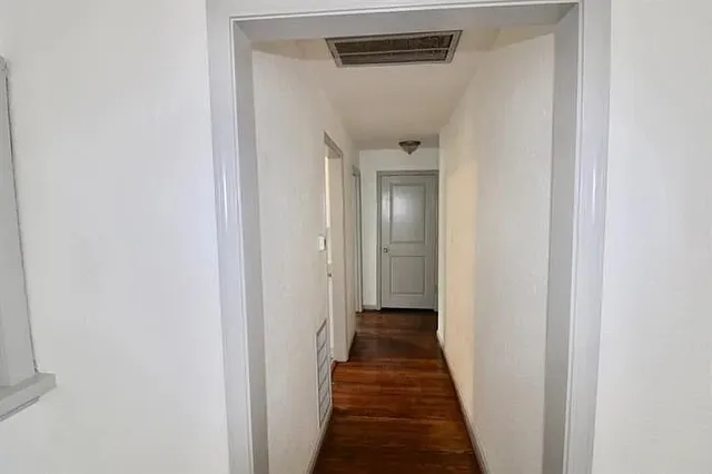 a view of a hallway with a wooden floor