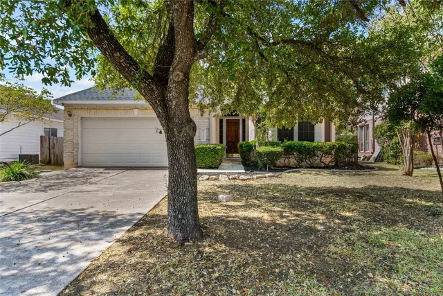 a front view of a house with a yard and tree
