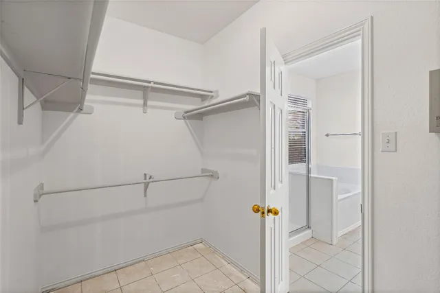 a view of walk in closet with empty racks