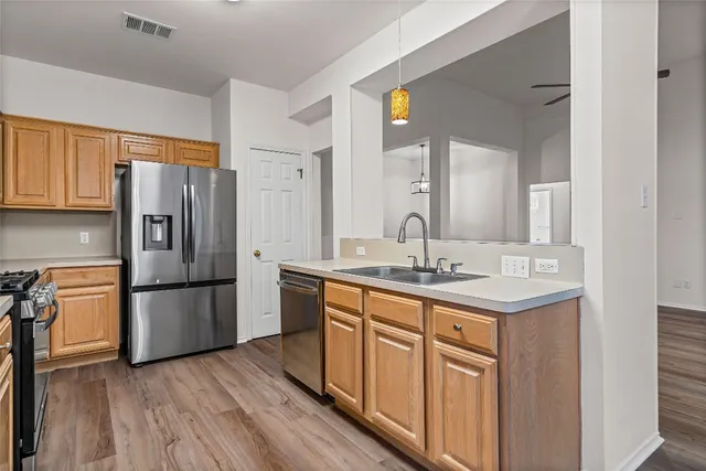 a kitchen with a refrigerator sink and cabinets