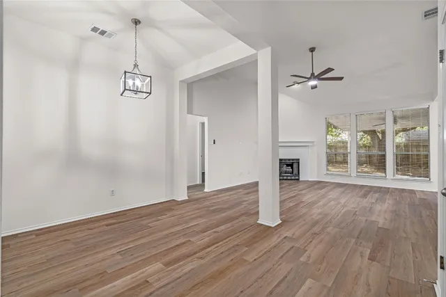 a view of empty room with wooden floor and window