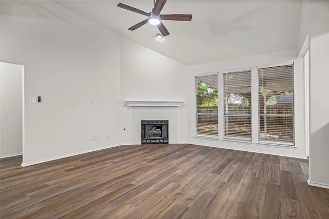 a view of empty room with wooden floor and fireplace