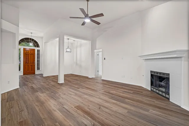 a view of empty room with wooden floor and fireplace