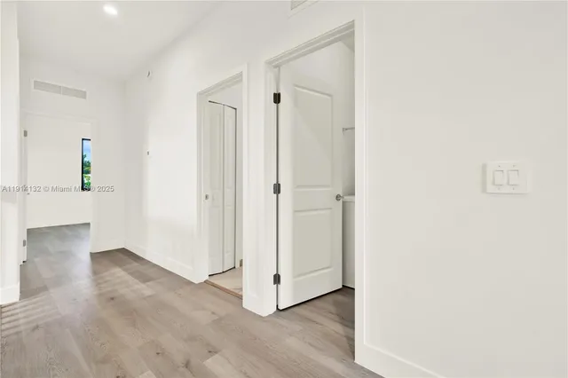 a view of a hallway with wooden floor