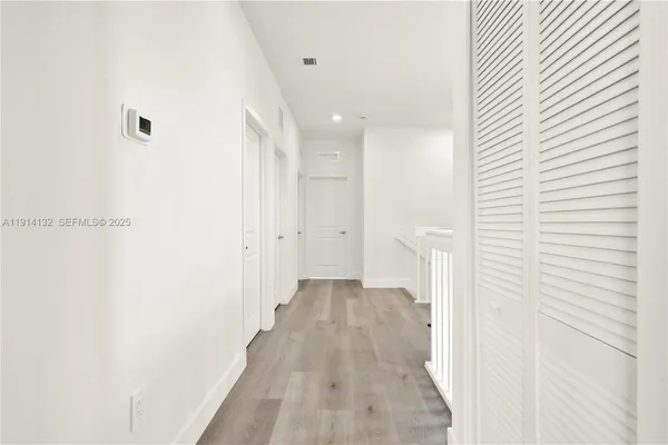 a view of a hallway with wooden floor