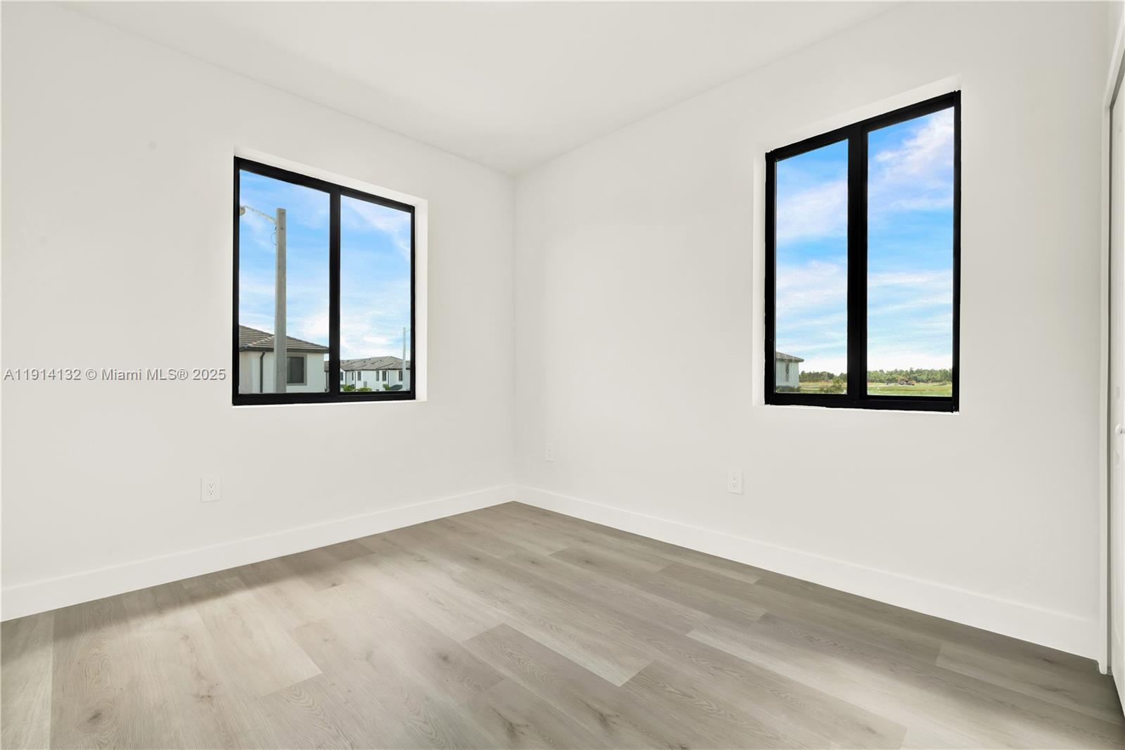 34520 Southwest 191st Court, Unit 34520 Homestead, FL 33034 - Photo 24 of 37 an empty room with wooden floor and windows
