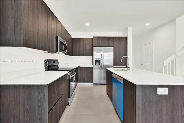 a kitchen with stainless steel appliances a sink and a refrigerator